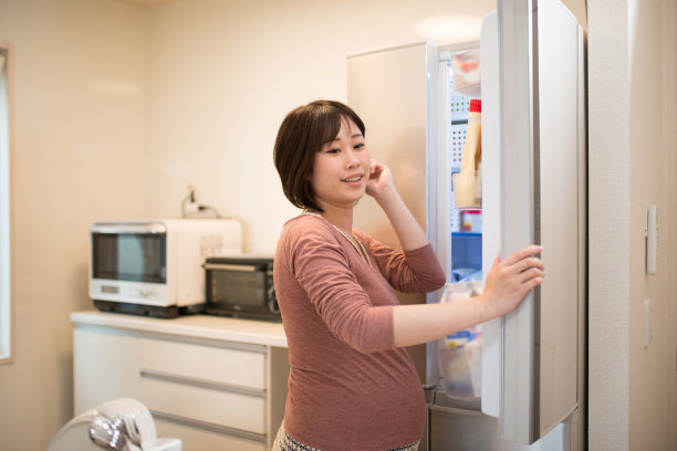 孕妇打开冰箱准备做饭图片下载