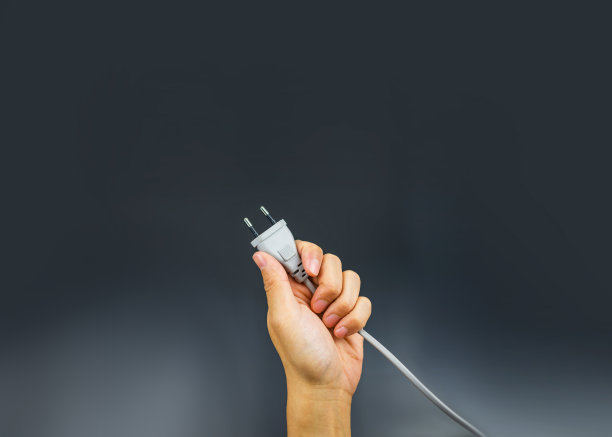 插头手握在黑色背景上图片下载