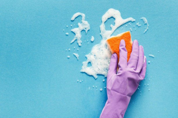 手戴手套，用海绵擦拭玻璃表面图片下载