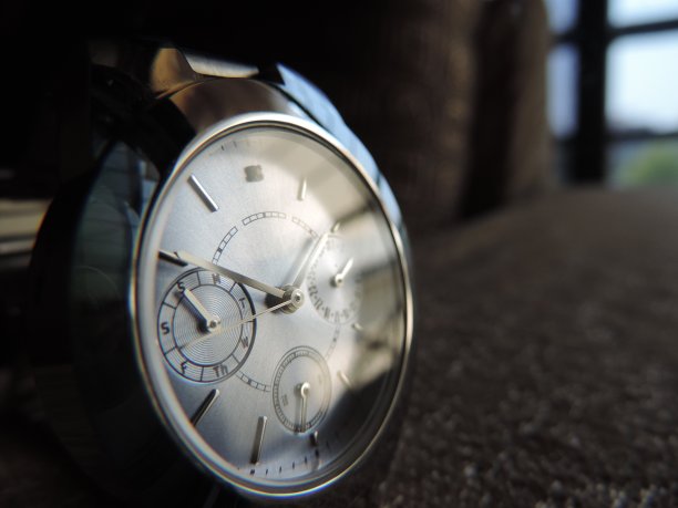 靠近窗户的金属铬腕表上的反光图片下载