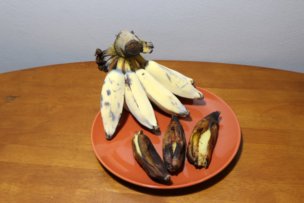 哈木香蕉，泰语名。木桌上棕色的盘子里放着烤熟的香蕉图片下载