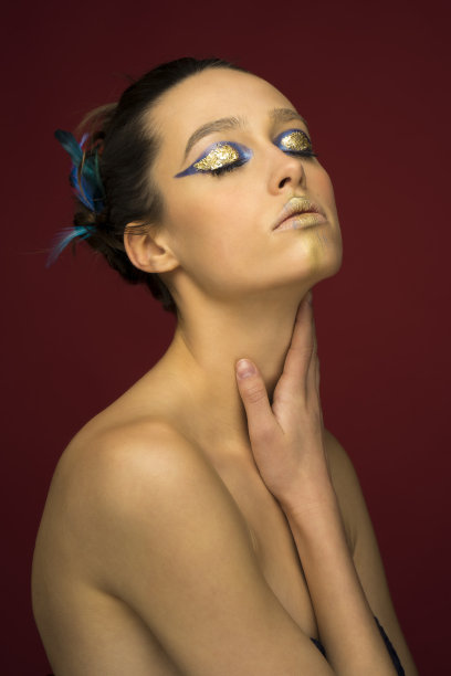 一个漂亮的年轻女孩的肖像，化着金色和蓝色的妆图片下载