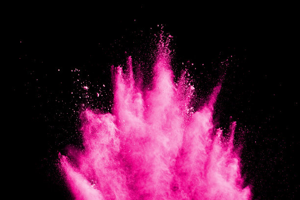 抽象的粉色粉尘爆炸在黑色背景。抽象的粉溅在黑色背景上，粉溅的冻结运动。图片下载