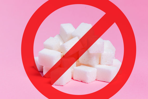 方糖穿过了作为禁止通行标志的圆圈内的红色条纹。粉红色的背景图片下载