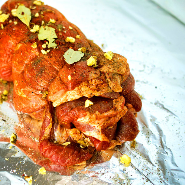 生腌猪肉卷，撒上香料，用细绳扎起来。躺在箔。图片下载