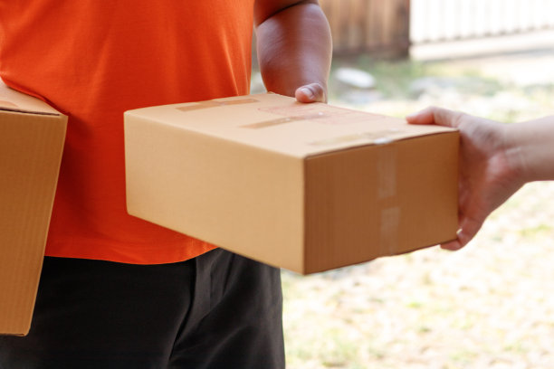 客户签署文件，并从送货员那里接收包裹。素材图片