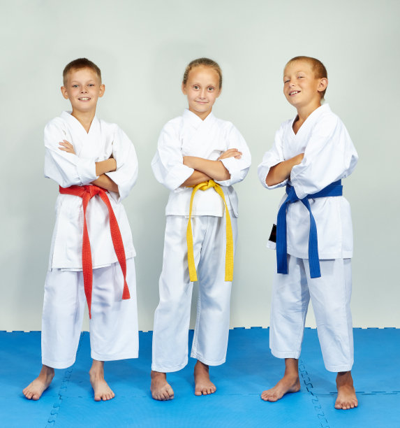 有趣的空手道运动员站在蓝色的垫子上图片下载