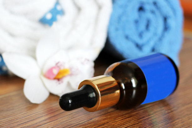 透明质酸瓶，加吸管，毛巾和兰花图片下载