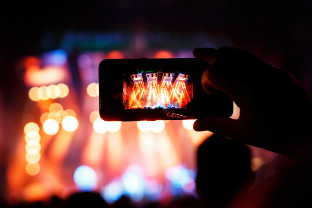 手用智能手机记录现场音乐节和音乐会舞台的照片。图片下载