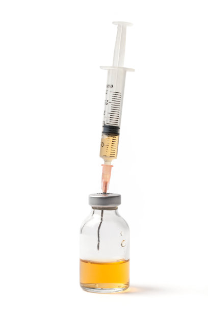 注射器在装有黄色液体的小瓶上图片下载