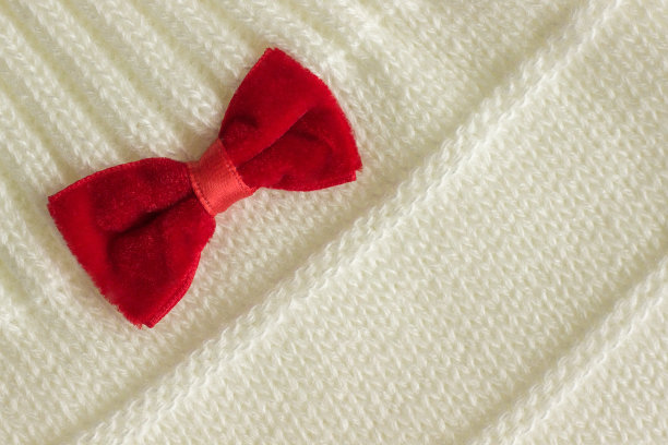 带红色蝴蝶结的白色针织织物图片下载