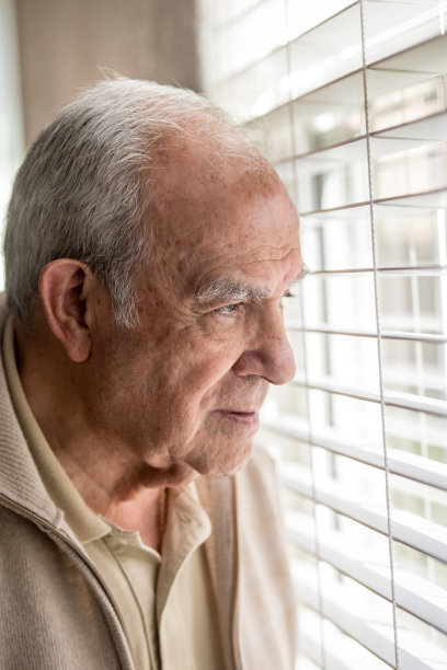 一位长者透过窗户向外看图片下载