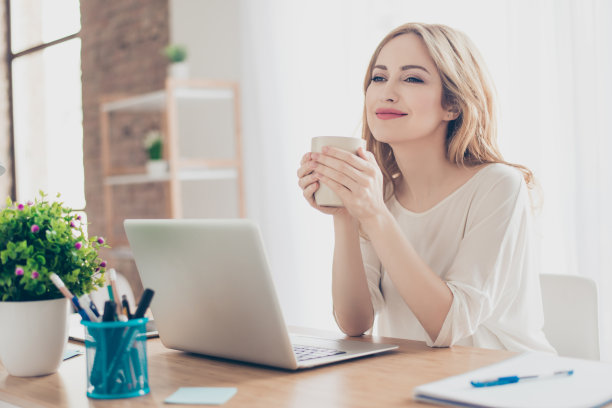 快乐漂亮可爱的女人工作与电脑享受咖啡图片下载