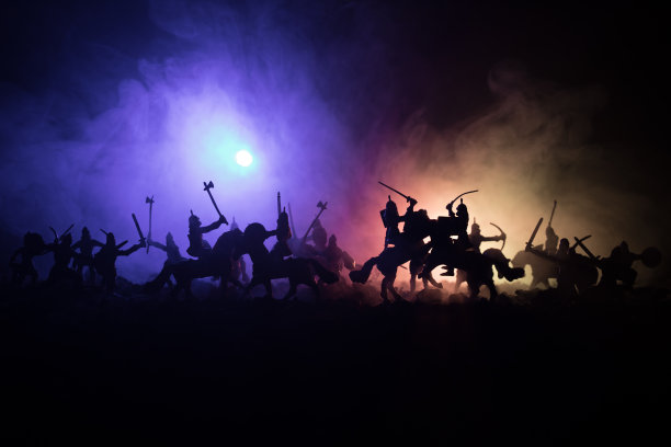 有骑兵和步兵的中世纪战斗场景。剪影的人物作为单独的对象，战斗的战士之间的黑暗色调的雾背景。夜景。图片下载