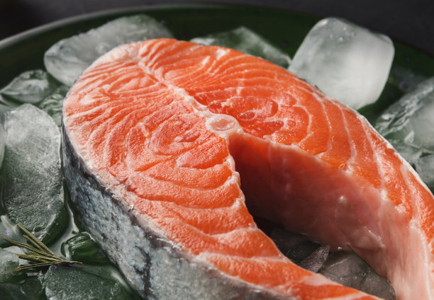 鲜嫩的鲑鱼配上冰，以深色为背景图片下载