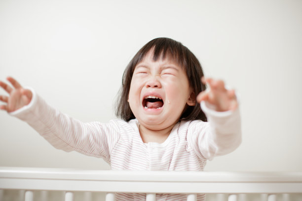 婴儿床上哭的小女孩图片下载