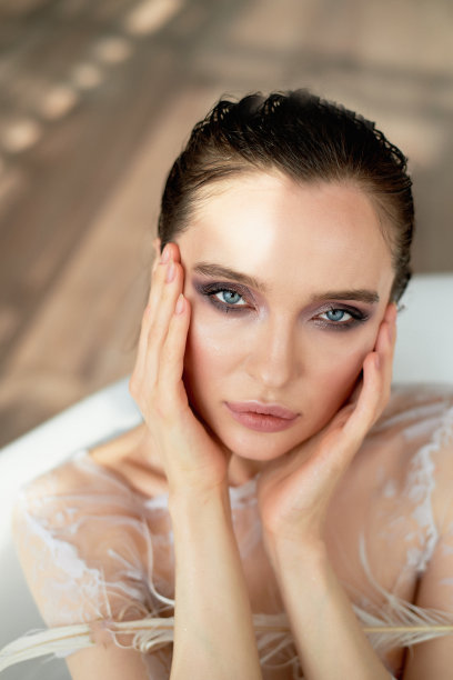 明亮的工作室。一个美丽女孩的肖像，丰满的嘴唇，纤细的手腕，湿漉漉的头发图片下载