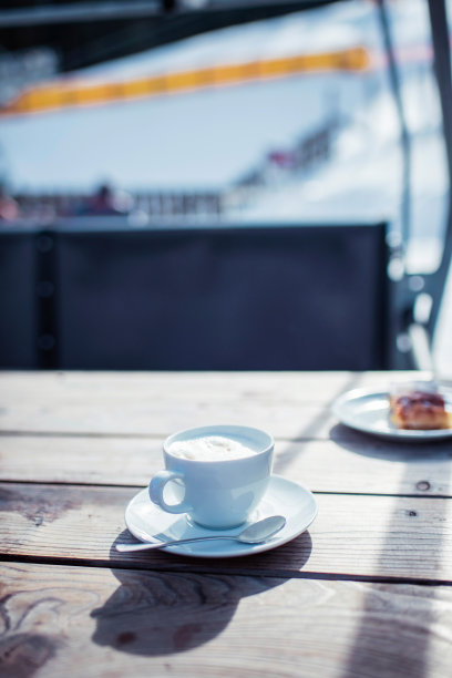 冬季运动区户外木制桌子上的咖啡杯和茶碟。图片下载