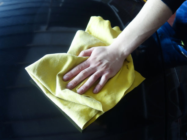 用黄色毛巾擦拭男性手车图片下载
