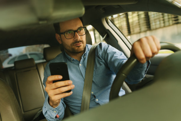商人在车里用手机。鲁莽驾驶图片下载