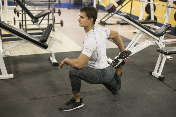 年轻人在健身房做伸展运动图片下载