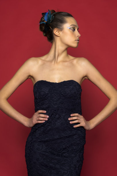 一个美丽的年轻女孩的肖像在一个优雅的长macramé蓝色裙子和金色的高跟鞋图片下载