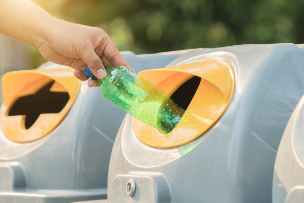 男人手将空塑料瓶扔进垃圾桶素材图片