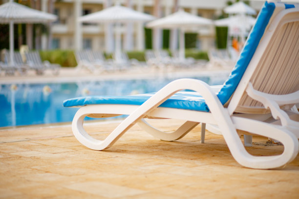 热带度假胜地的游泳池里的躺椅图片下载