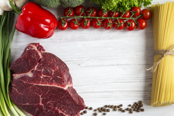 新鲜生肉牛肉配樱桃番茄，意大利面，健康食品。白色木制背景。副本的空间。图片下载