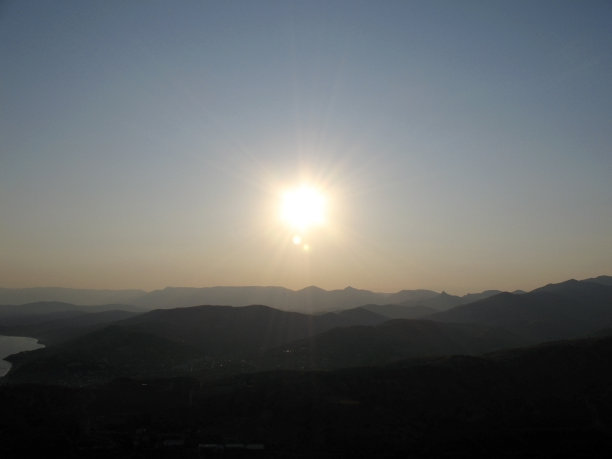 夕阳照过山顶。图片下载