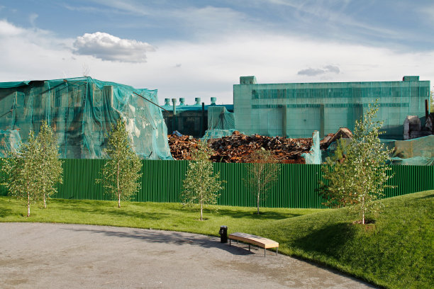 在城市公园围栏后面准备拆除的旧工厂图片下载