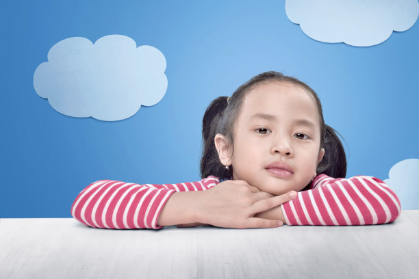 快乐的亚洲小女孩放松在桌子上图片下载