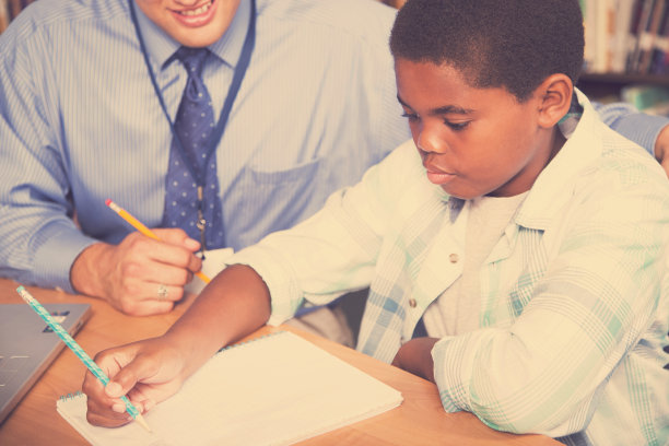 老师，导师帮助小学生完成家庭作业。图片下载