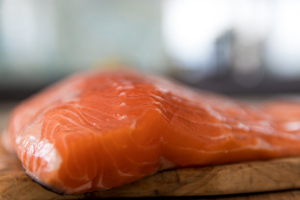 木桌上放着一大块生鲑鱼素材图片