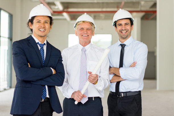 戴安全帽的三个微笑伙伴的肖像图片下载