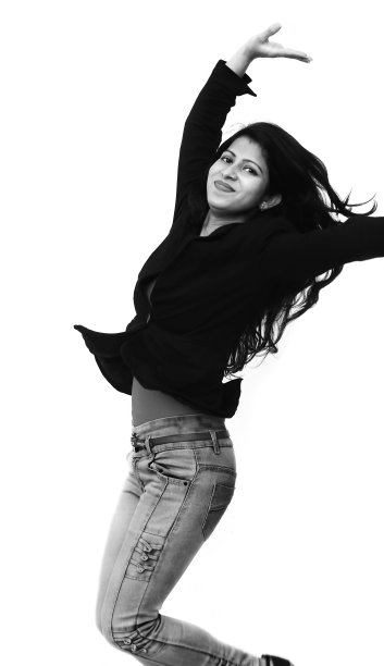 快乐的女孩在白色的背景下跳跃图片下载