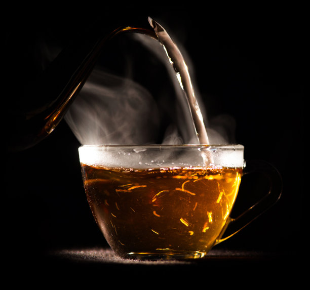 把热茶从茶壶倒进玻璃杯里图片下载
