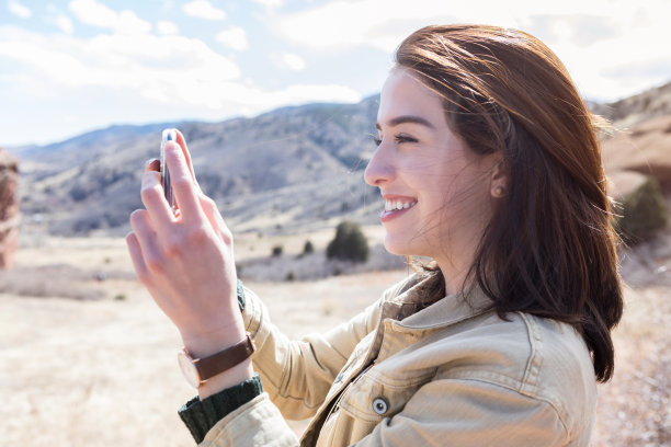 年轻女子在风景优美的岩石峡谷拍照图片下载