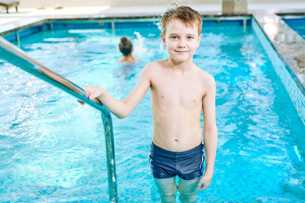 高兴的男孩从游泳池出来图片下载