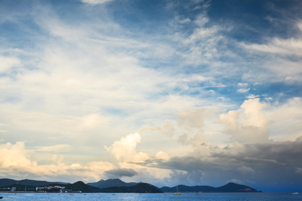 中国海南岛三亚市大东海湾。蓝色的海，山脉和多云的天空图片下载