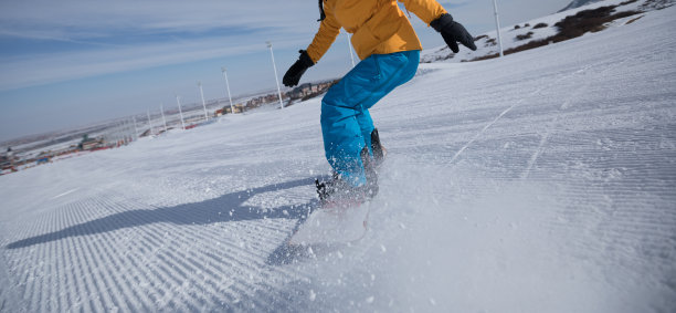 滑雪板在冬季滑雪胜地的斜坡上下降图片下载