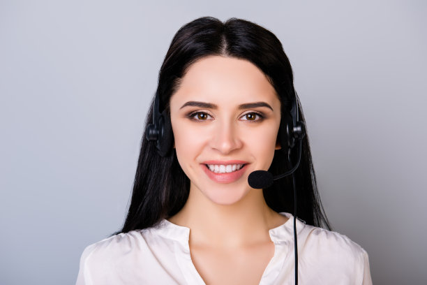 年轻的呼叫中心顾问在灰色背景下戴着耳机图片下载