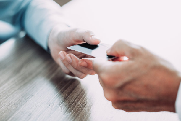 桌子上面的男性给信用卡的手特写。无法辨认的商人支付账单或传递名片给合作伙伴。银行或购物概念图片下载