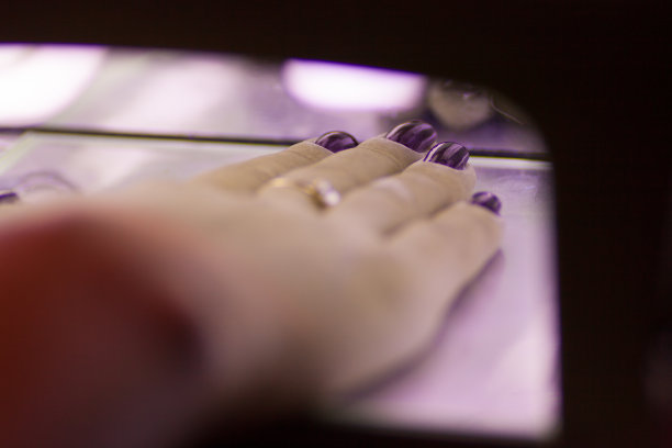 紫外线灯里一个女人的手的特写图片下载