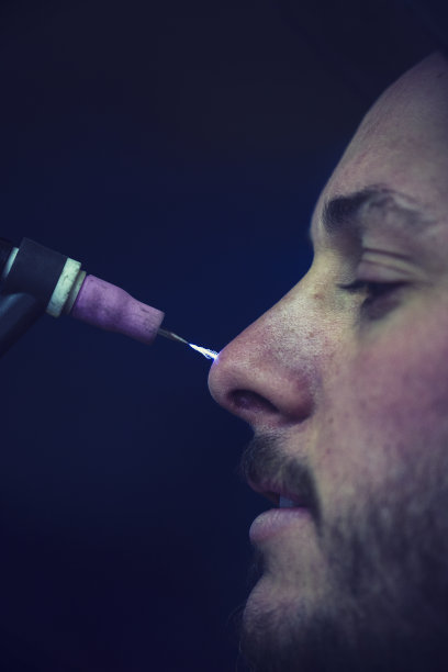 一个拿着手电筒照脸的男人的肖像图片下载