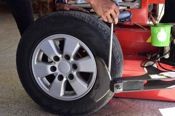 工人使用轮胎更换机从合金轮毂上拆卸轮胎图片下载