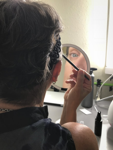 一个女人在镜子前化妆图片下载