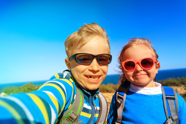 快乐的小男孩和小女孩在大自然中自拍旅行图片下载