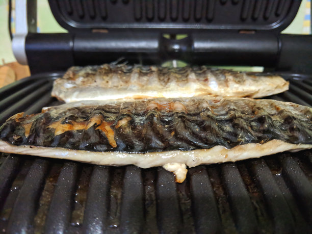 烤鲭鱼，金烤皮鱼，自制菜，黑色烤面，亚洲菜，节日餐桌上的炸鱼，复古风格的食物图片下载