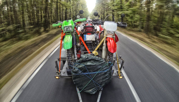 带着越野旅行的摩托车和汽车在路上行驶图片下载